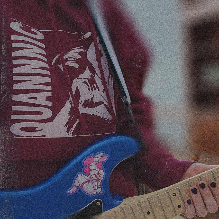 Twilight wearing a quannnic hoodie as shes holding her guitar.
